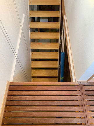 ルーバー状に組まれた2F南面床から鉄骨フレームの新しい階段を見る