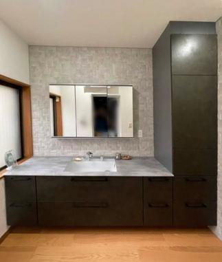 レリーフパネルの壁材と透明感あるカウンターが映える洗面空間