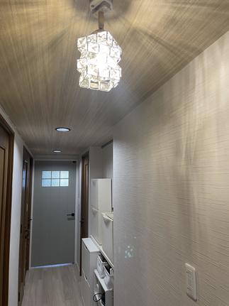 リビング側から玄関につながる廊下の天井は柔らかい木目カラーの壁紙に！