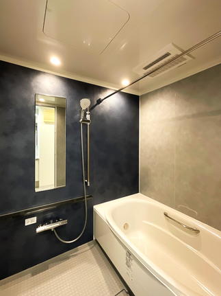 シックなブルーのアクセントパネルが映えるバスルーム