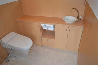 トイレの収納家具は便器や手洗鉢の位置に配慮し、最善の収納を設計したオーダー家具です。美濃焼きの手洗鉢が優しげです。