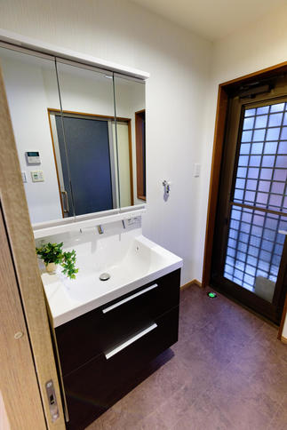 家族の裏玄関としての役目も担っていた洗面室。玄関を移動してゆっくり身支度ができ、洗濯機スペースを備えて快適になりました。