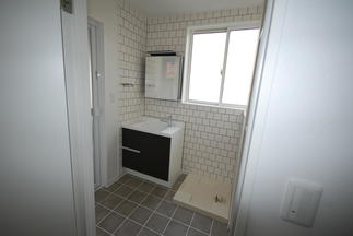 壁、天井のタイルがアクセントとなっている洗面脱衣所