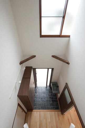 二階を減築し、吹き抜けを作ったことで明るく開放的な空間となった玄関ホール。