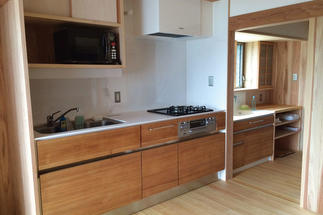 新設したキッチンは、内装に合わせて木目調に。キッチン横（右奥）は洗面室
