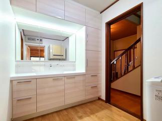 収納量抜群な洗面化粧台。扉は人気のベージュウッド柄。