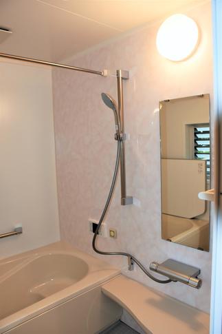 ピンクのアクセント壁が優しい雰囲気の浴室