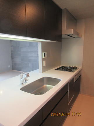 設備はそのままで既存の白いキッチンからモダンなダーク木目に変更しました。