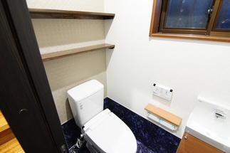 小物も飾れる棚を備えた機能的なトイレ