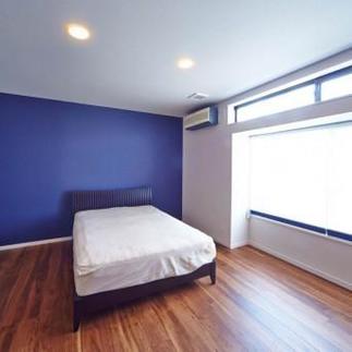 ブルーのアクセントクロスが印象的な落ち着きのある寝室