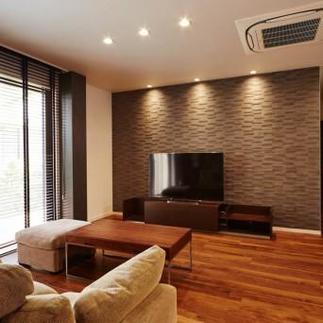 エコカラットタイルを壁一面に貼り付け重厚感溢れるリビングに。