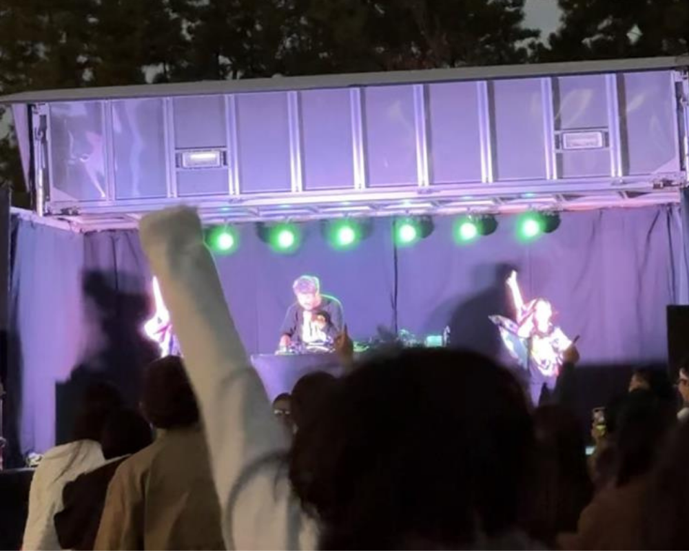 DJダイノジが屋外ステージでパフォーマンス。観客が腕を上げて盛り上がる夜のライブ。.pngのサムネイル画像