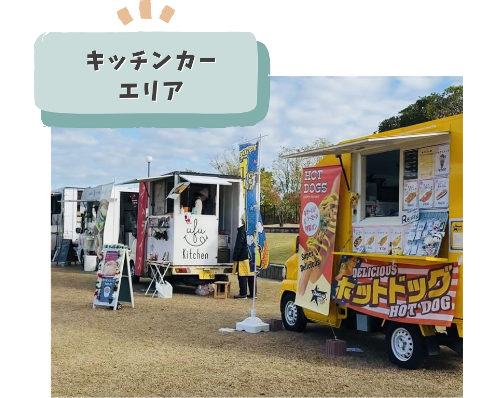 芝生広場に並ぶキッチンカー。ホットドッグや軽食を提供する屋外フードエリア。.png