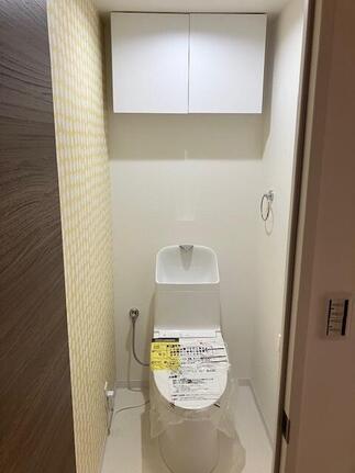 北欧風クロスと吊り戸棚のあるトイレ